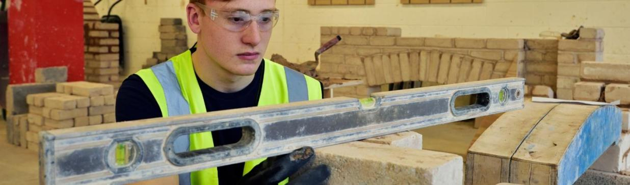 WMC Brickwork Construction Skills student measuring inside of a classroom