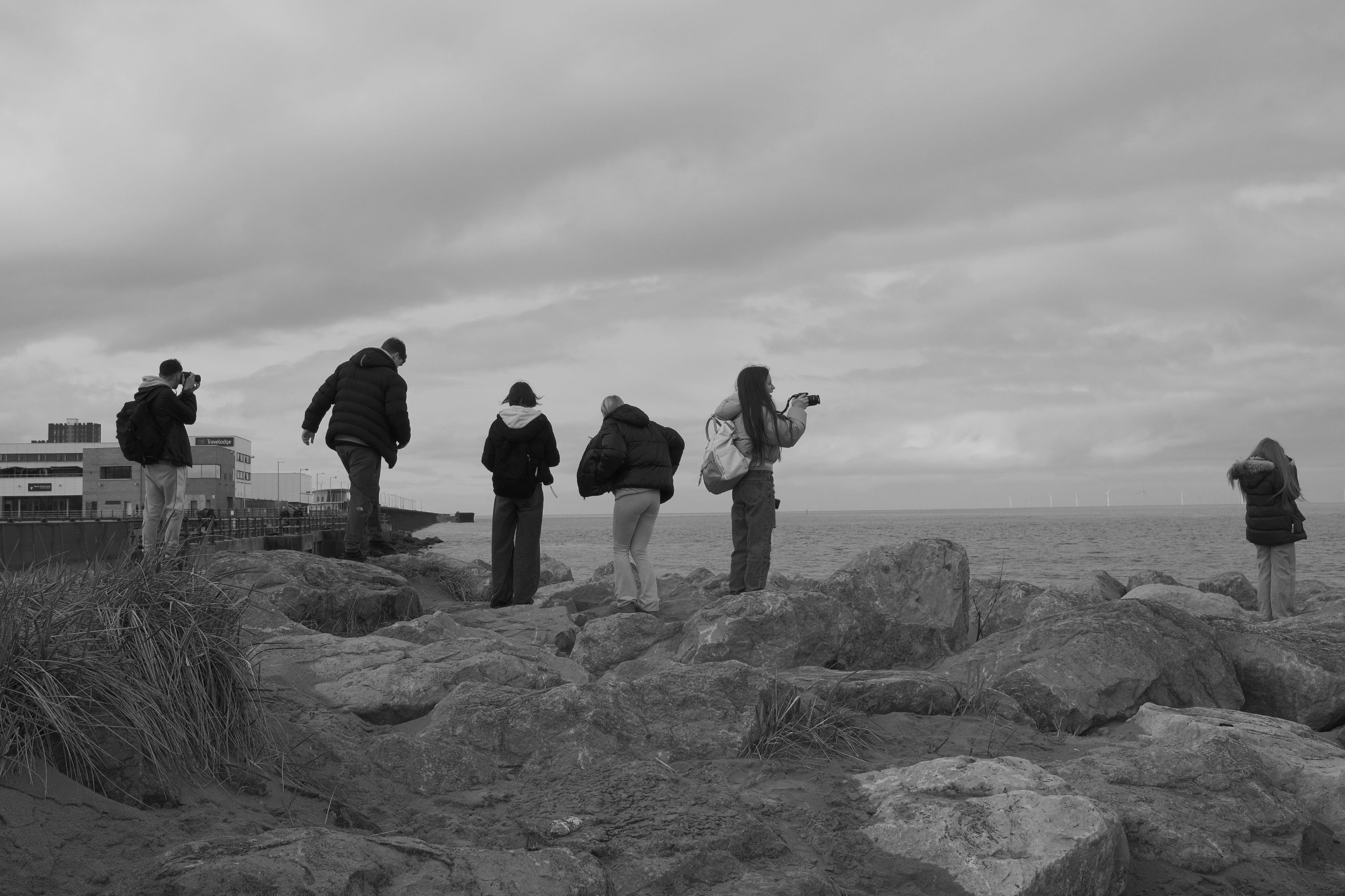 Students on the rocks at New Brighton taking photos