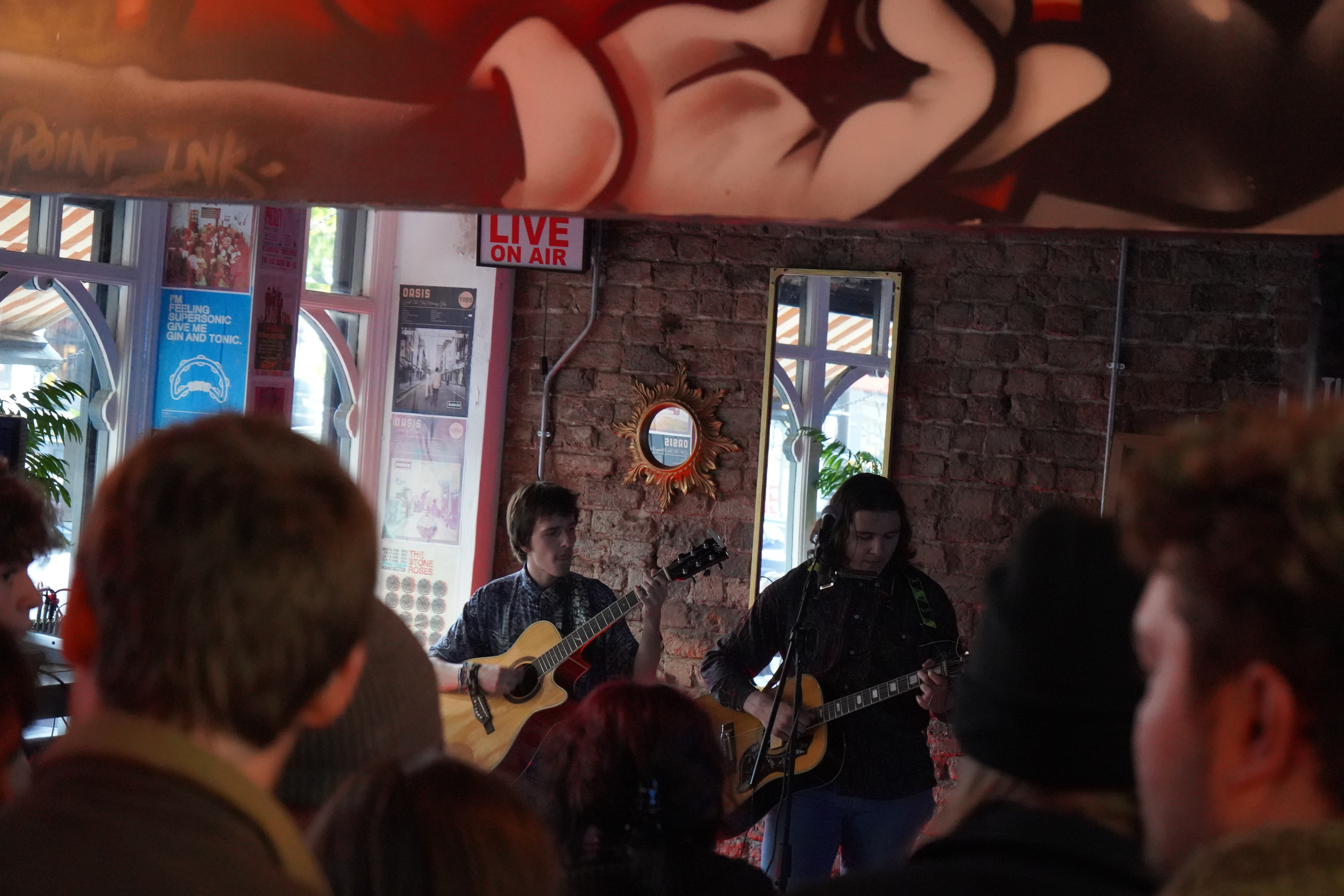 Two male students performing with acoustic guitars at Rockpoint Records