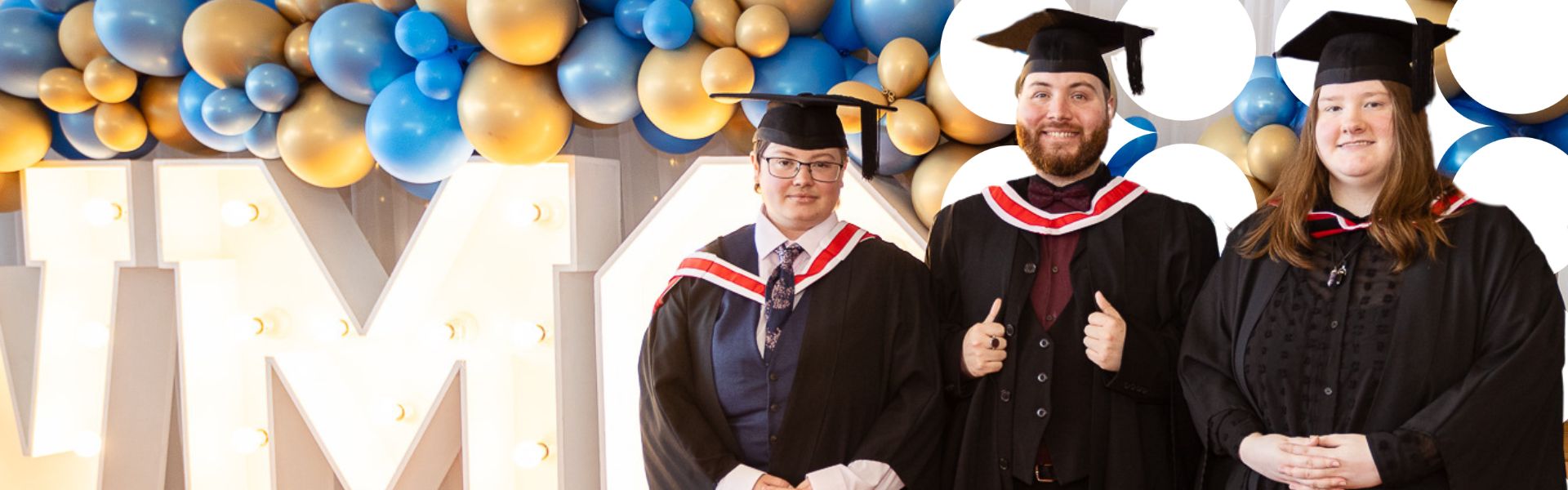 Three Wirral Met graduates smile as they celebrate at their graduation ceremony.