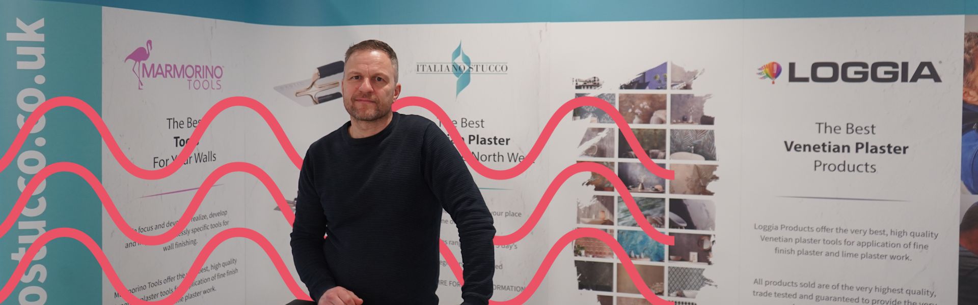 Construction employer stood in front of a promotional banner 