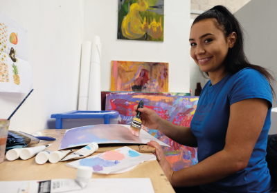 Female Part Time Art And Design Student Inside A Classroom Painting