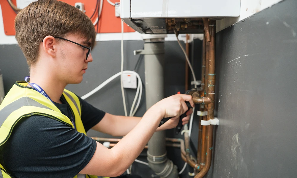 Plumbing and Gas student working with pipes inside workshop