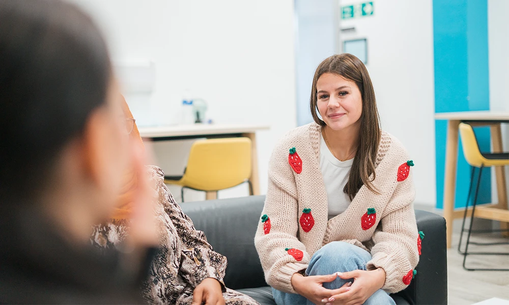 Access to HE student sitting down at out Hamilton campus break room