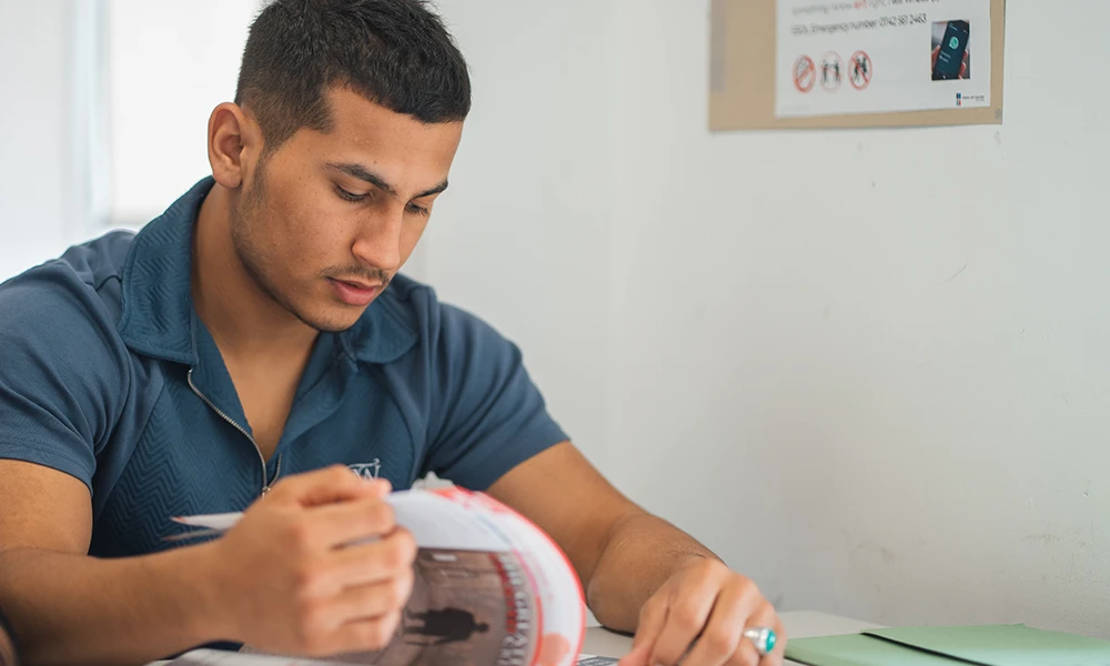 Social Studies student sat inside classroom looking at a book