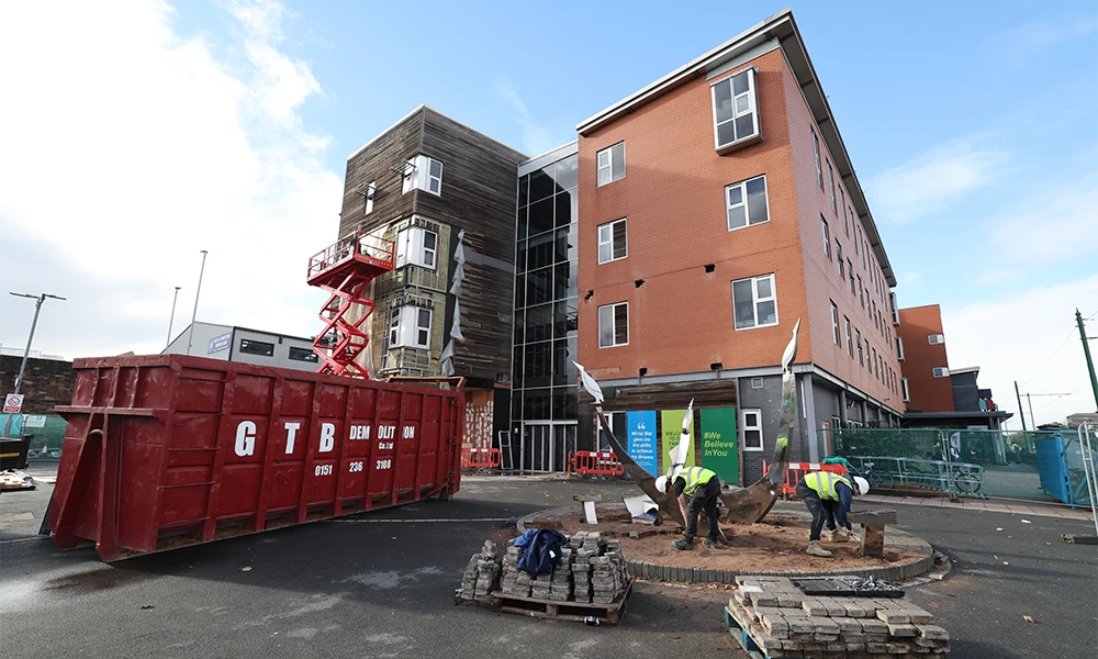 Brown Building with workmen outside