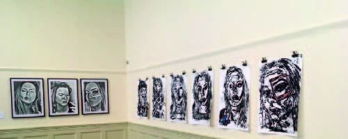 Fine Art Degree Show wall with black, white and red portrait paintings