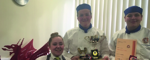 three successful hospitality and catering students holding their awards from chef competition